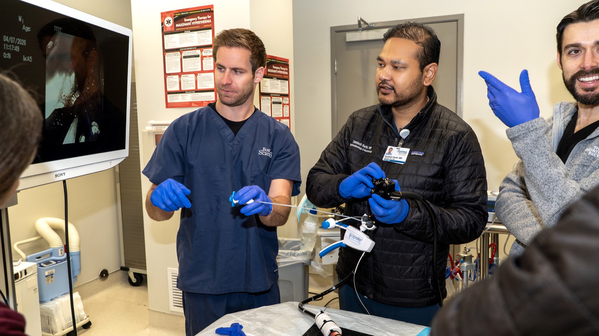 Dr. Sandesh Karki and a fellow demonstrating an Apollo endoscopic suturing device with live monitor view