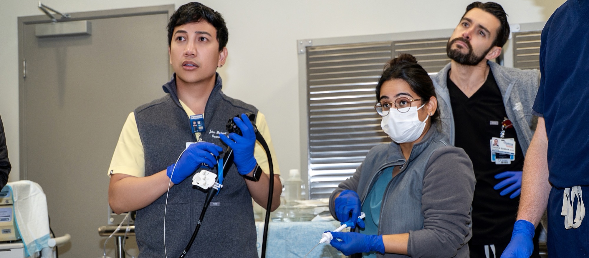 Fellows handling an endoscope and accessory tool during a training session