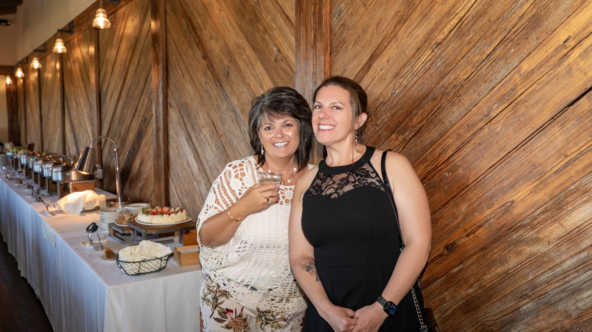 Guests smiling together in front of the dessert table