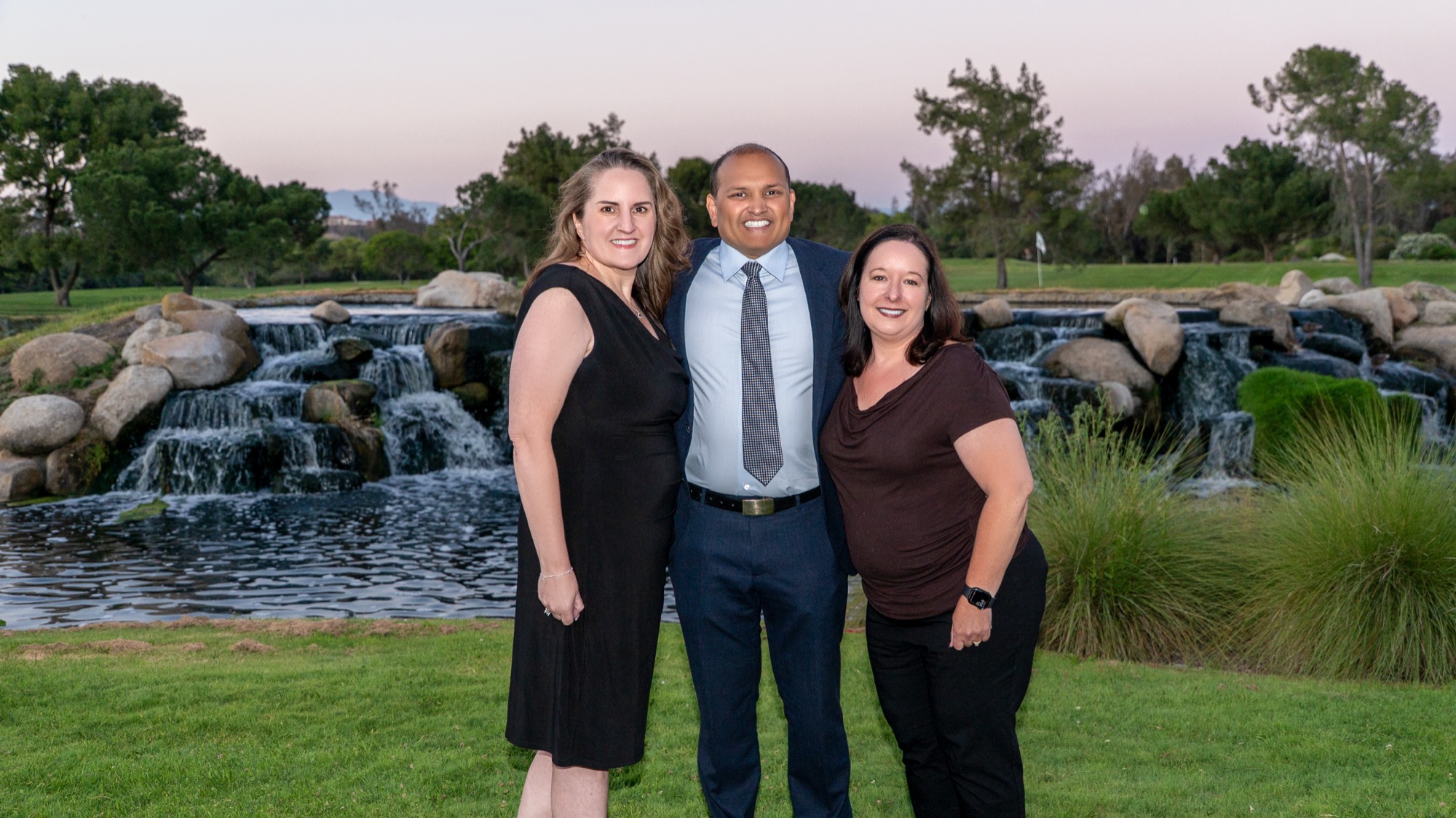 Dr. Veluvolu with colleagues by the waterfall at sunset