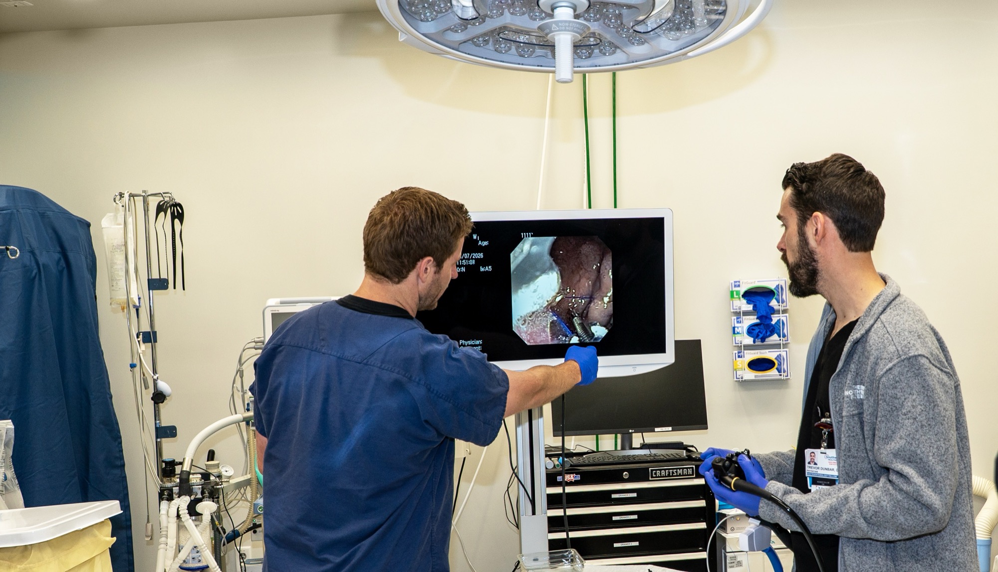 Dr. Trevor Dunbar and a fellow performing a live endoscopy while watching the monitor