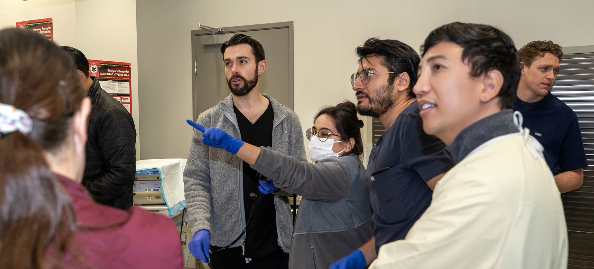 Mentor pointing out anatomy on the monitor as fellows follow along